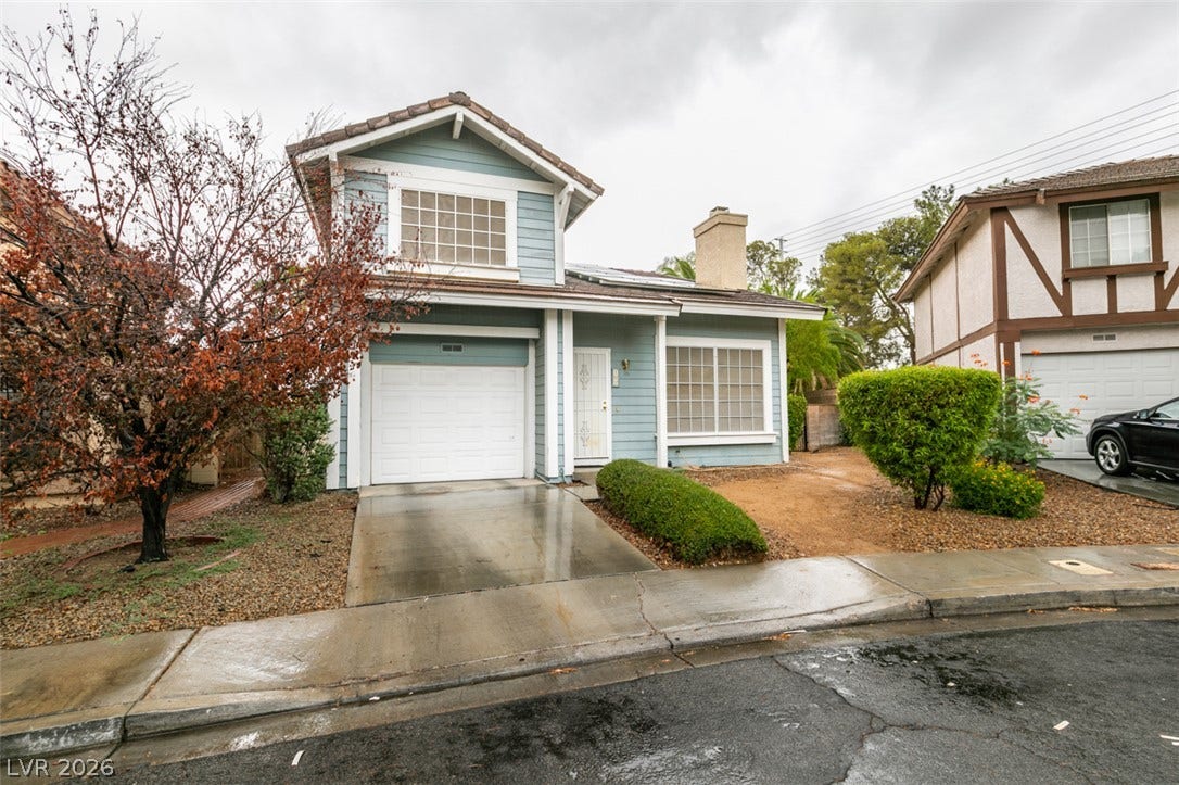 Classic multi-level exterior architecture features a concrete driveway and attached garage.