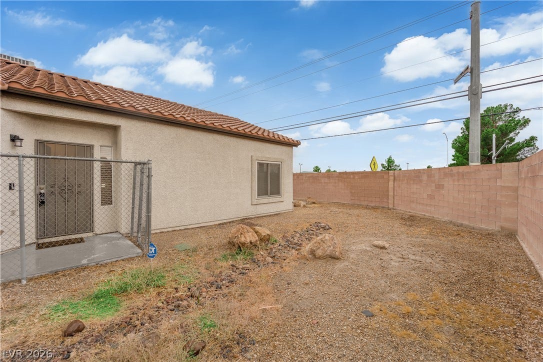 2653 Thunder Struck Court, North Las Vegas, NV 89030 Enclosed block walls border a low-maintenance dirt yard behind this stucco home.