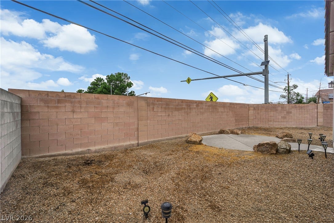 2653 Thunder Struck Court, North Las Vegas, NV 89030 An enclosed backyard features gravel landscaping alongside a concrete patio pad.