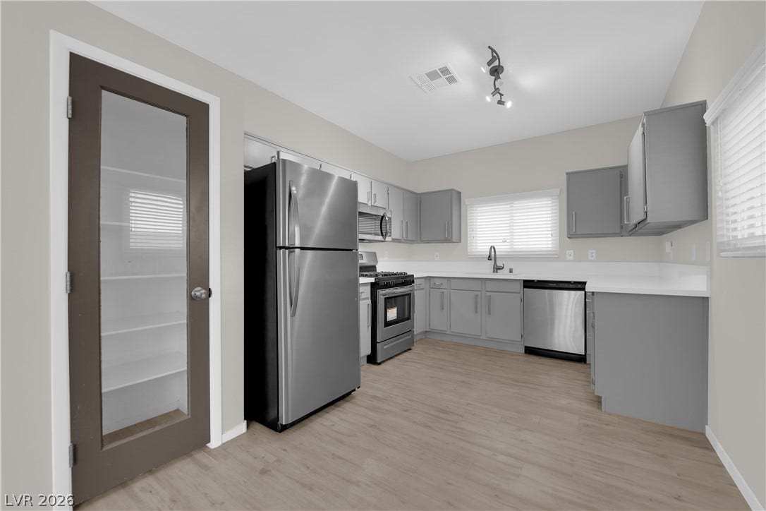 2653 Thunder Struck Court, North Las Vegas, NV 89030 A glass-paneled pantry door opens to a kitchen featuring clean cabinetry and stainless steel appliances.