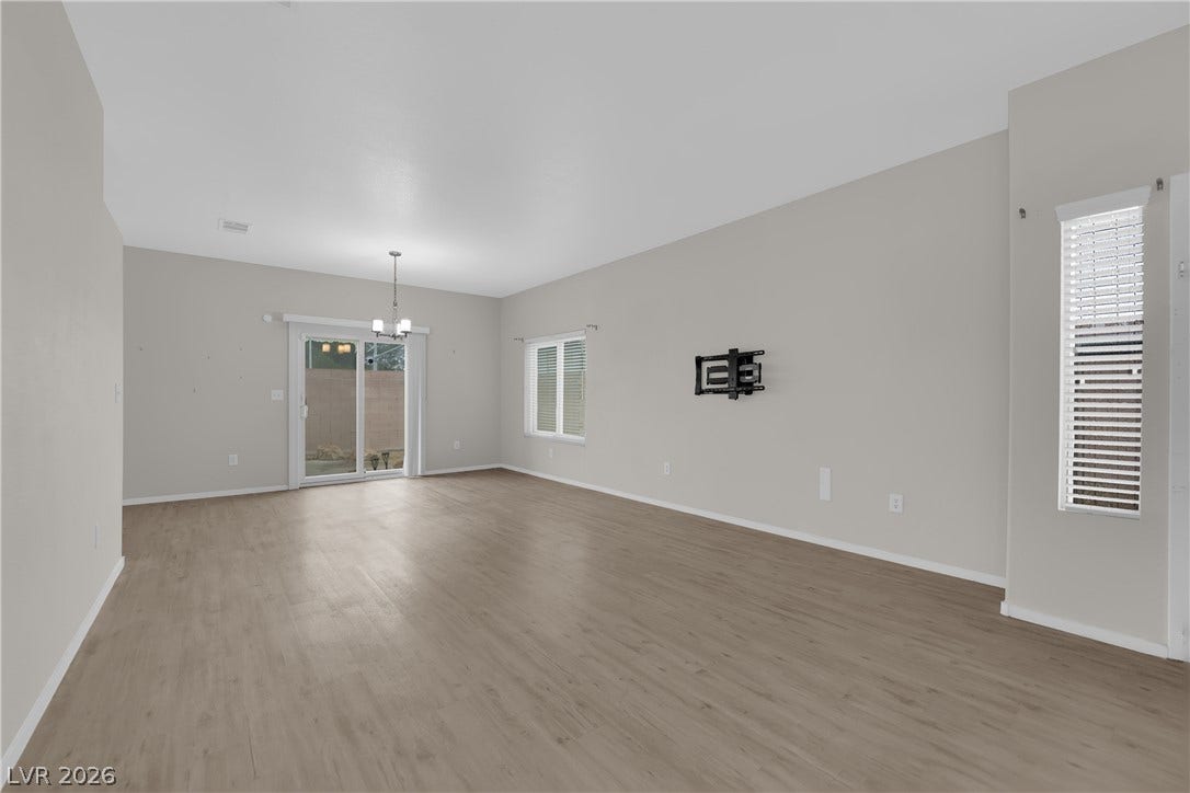 2653 Thunder Struck Court, North Las Vegas, NV 89030 Smooth wood-style flooring runs throughout a flexible living space illuminated by sliding glass doors.