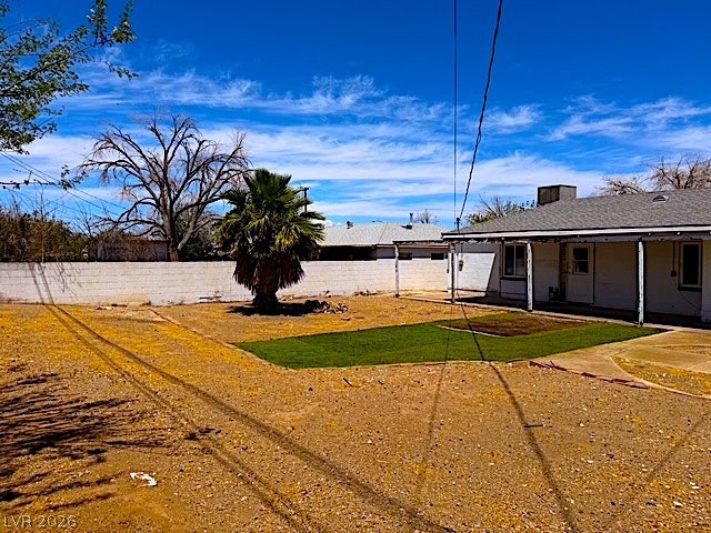107 Joshua Street, Henderson, NV 89015 A spacious backyard features a covered porch alongside a large desert landscape area and artificial lawn.
