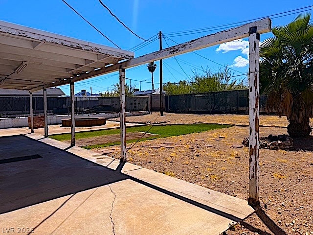 107 Joshua Street, Henderson, NV 89015 A spacious covered patio overlooks a large fenced backyard under clear desert skies.