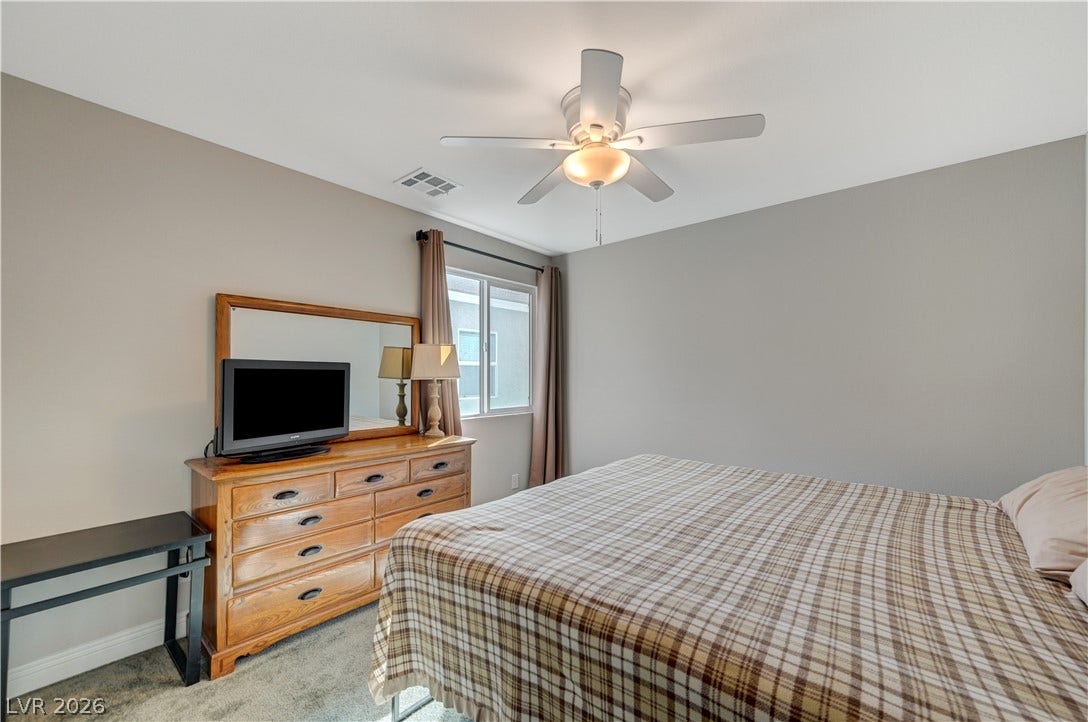 6629 Rockhouse Street, North Las Vegas, NV 89086 Carpeted flooring and a window framing neighborhood views ground this quiet bedroom.