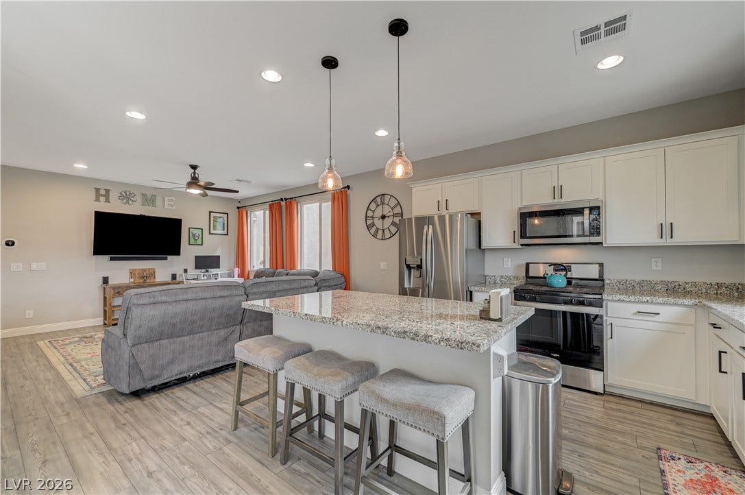 6629 Rockhouse Street, North Las Vegas, NV 89086 An open-concept kitchen transitions seamlessly into the adjacent living space over wood-look flooring.