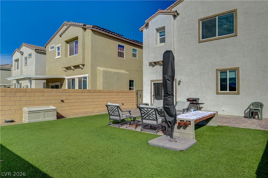 6629 Rockhouse Street, North Las Vegas, NV 89086 An inviting backyard features low-maintenance synthetic turf and a brick privacy wall.