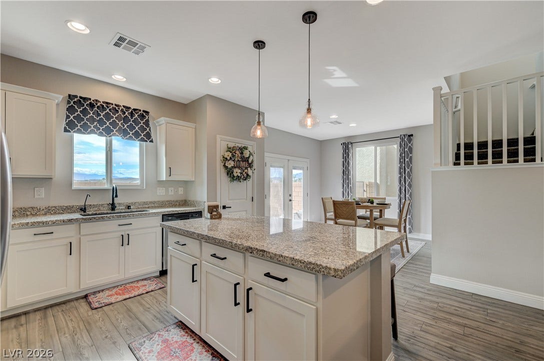 6629 Rockhouse Street, North Las Vegas, NV 89086 Polished granite countertops and classic wood-look flooring anchor this airy, open kitchen space.