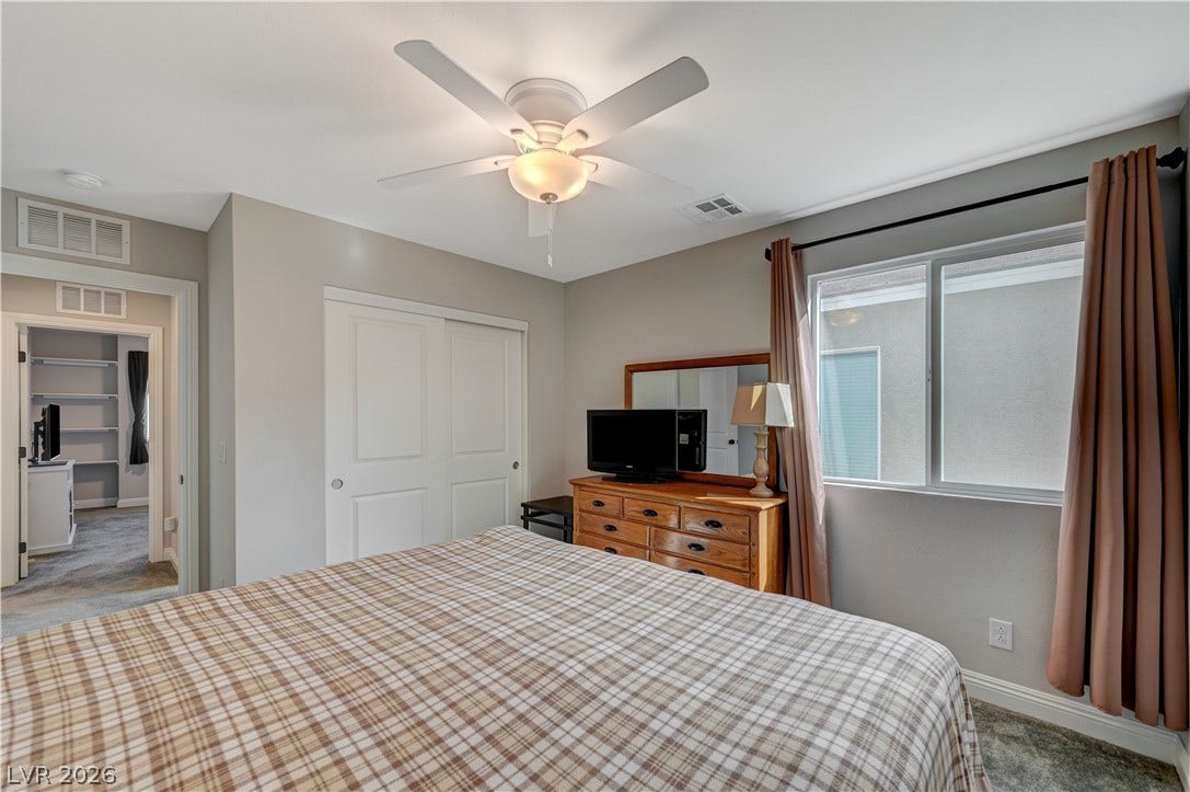 6629 Rockhouse Street, North Las Vegas, NV 89086 Plentiful natural light fills this comfortable bedroom featuring sliding closet doors and carpet flooring.