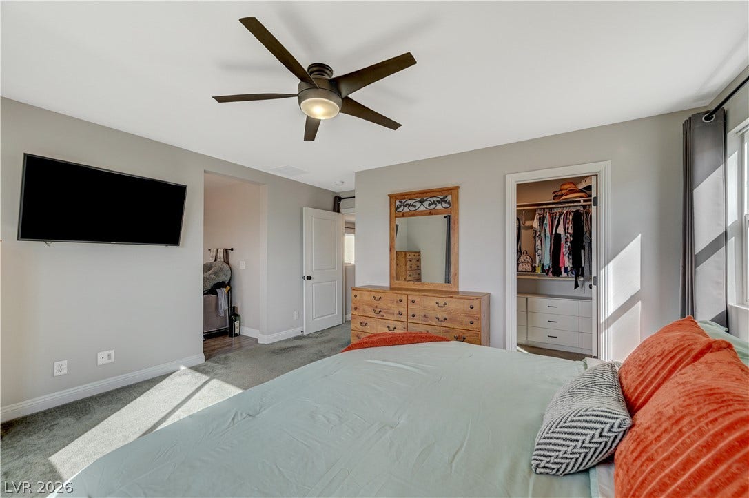 6629 Rockhouse Street, North Las Vegas, NV 89086 Natural light streams across this spacious bedroom featuring plush carpeting and a walk-in closet.