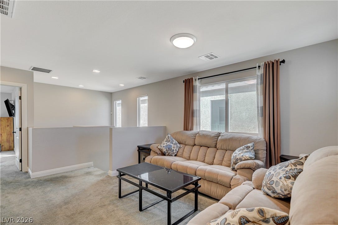 6629 Rockhouse Street, North Las Vegas, NV 89086 An upper-level loft features wall-to-wall carpeting and abundant natural light from multiple windows.