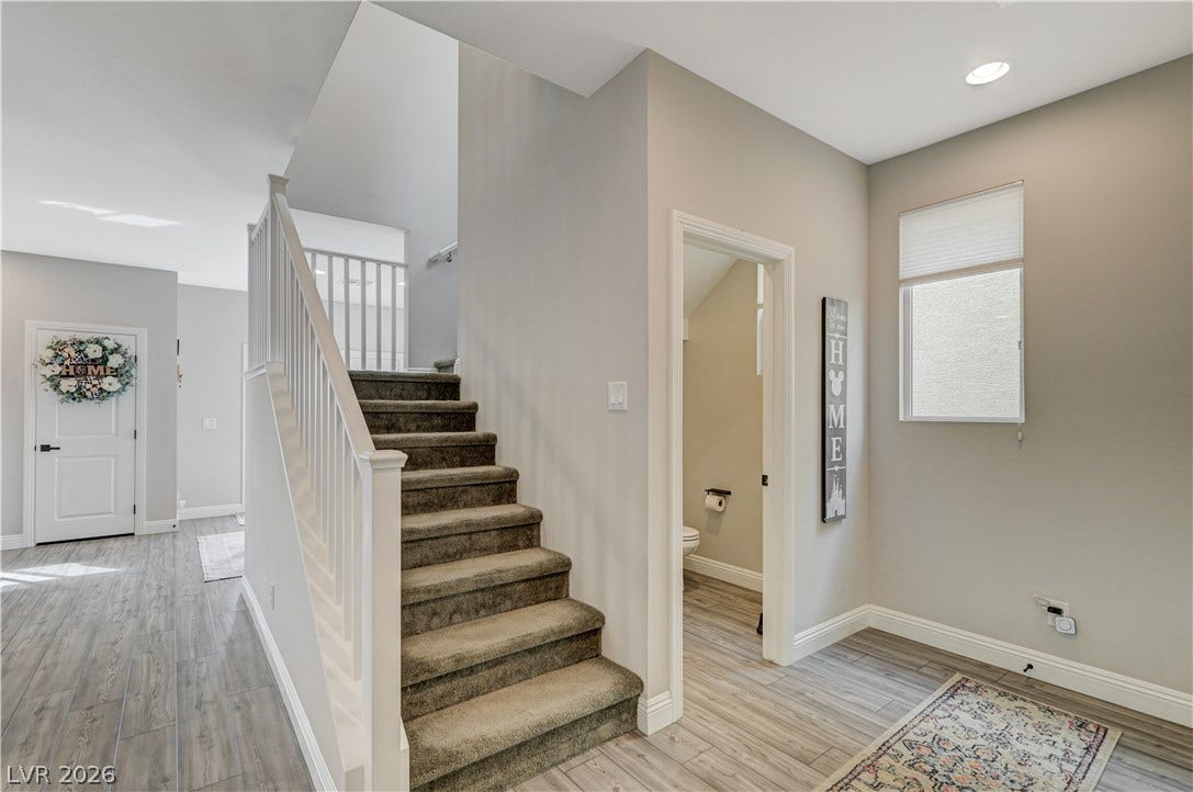 6629 Rockhouse Street, North Las Vegas, NV 89086 A carpeted staircase ascends next to a convenient powder room under recessed lighting.