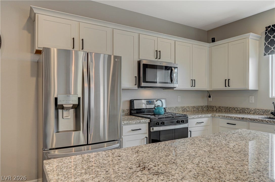 6629 Rockhouse Street, North Las Vegas, NV 89086 Polished granite countertops complement classic shaker-style cabinetry in this modernized workspace.