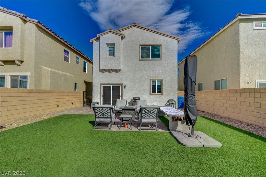 6629 Rockhouse Street, North Las Vegas, NV 89086 An enclosed backyard features low-maintenance synthetic turf and a paved patio area.