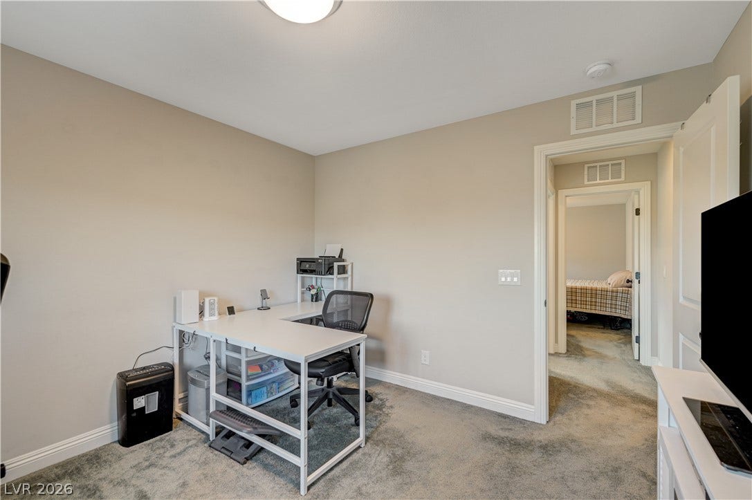 6629 Rockhouse Street, North Las Vegas, NV 89086 Plush carpeting and crisp white trim enhance this versatile home workspace.