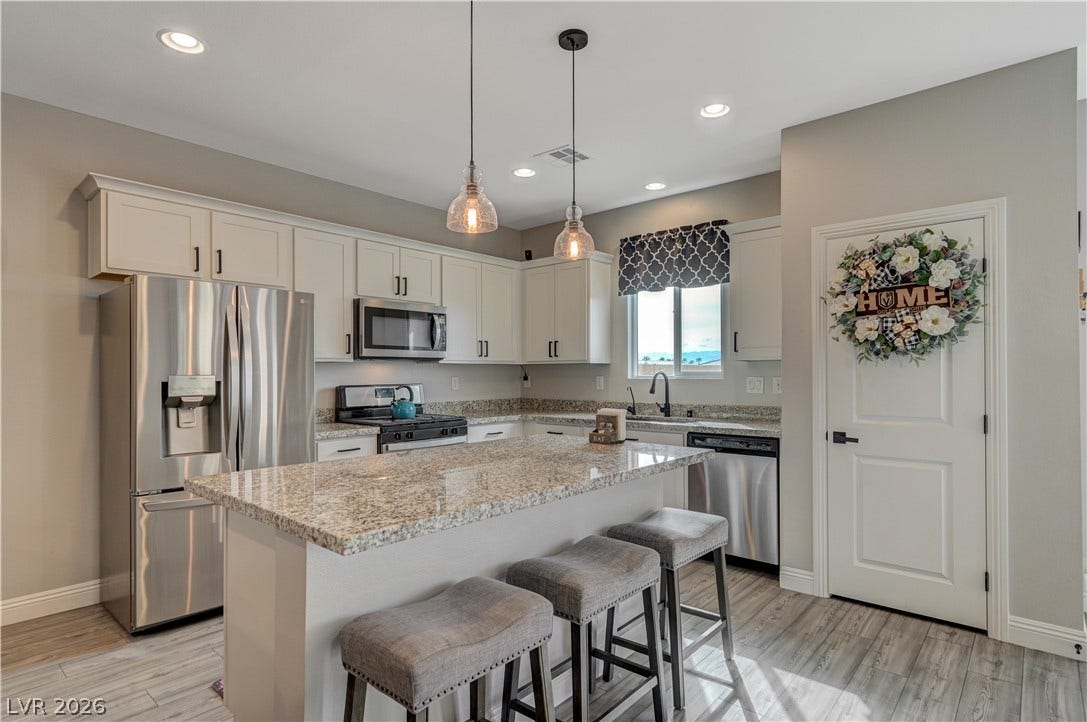 6629 Rockhouse Street, North Las Vegas, NV 89086 Polished granite countertops and classic cabinetry anchor this culinary space with a central island.