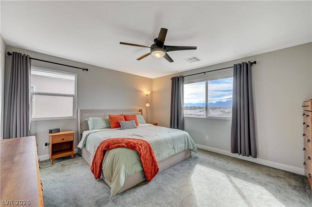 6629 Rockhouse Street, North Las Vegas, NV 89086 Generous windows frame distant mountain views from this carpeted bedroom.
