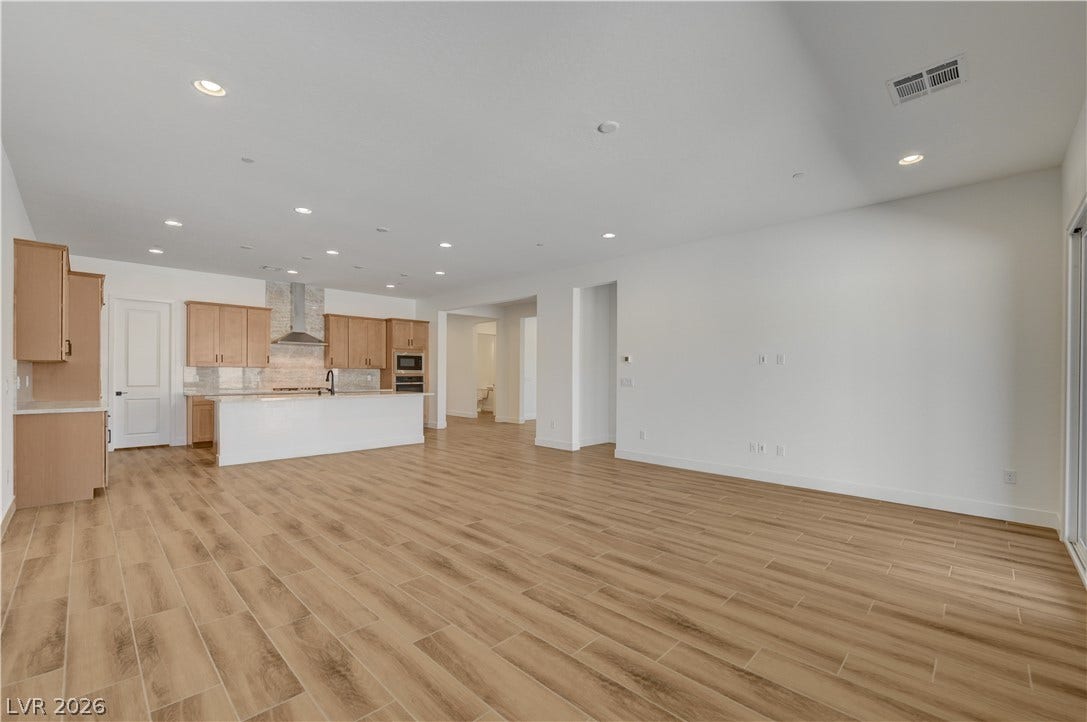 5689 Searching Bear Court, Las Vegas, NV 89149 An open concept living area transitions seamlessly to a sleek, modern kitchen, creating an inviting entertainment space.