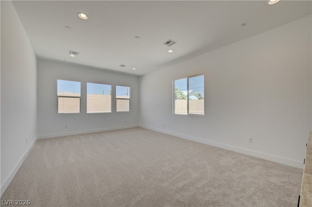 5689 Searching Bear Court, Las Vegas, NV 89149 A spacious room offers ample natural light through multiple windows, complemented by recessed lighting.