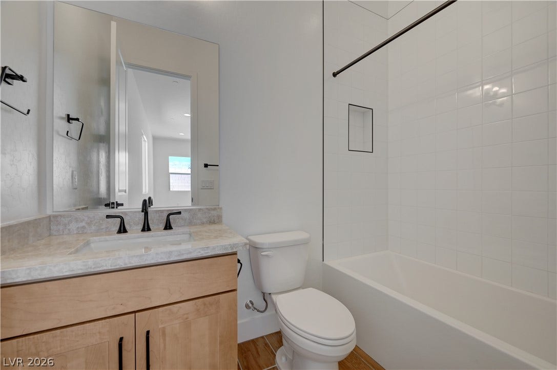 5689 Searching Bear Court, Las Vegas, NV 89149 A well-appointed bathroom with a sleek vanity and a tiled shower-tub combination.