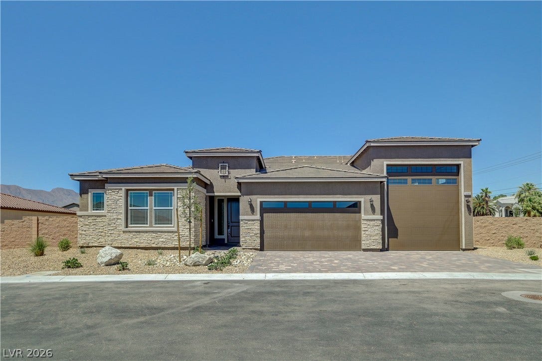 5689 Searching Bear Court, Las Vegas, NV 89149 Modern desert architecture with stone accents and a paver driveway creates compelling curb appeal.