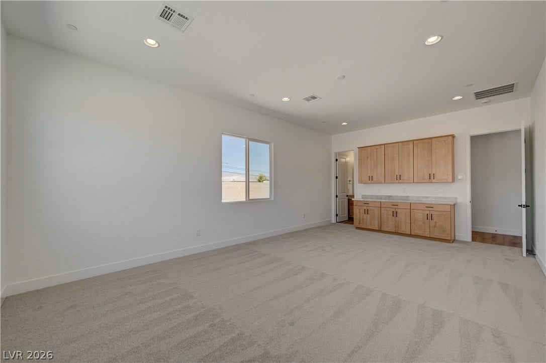5689 Searching Bear Court, Las Vegas, NV 89149 A versatile room provides abundant space, equipped with built-in cabinetry and countertops for practical utility.