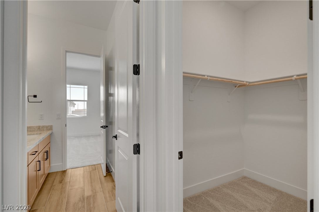 5689 Searching Bear Court, Las Vegas, NV 89149 Functional walk-in closet featuring carpeted flooring and ample storage space.