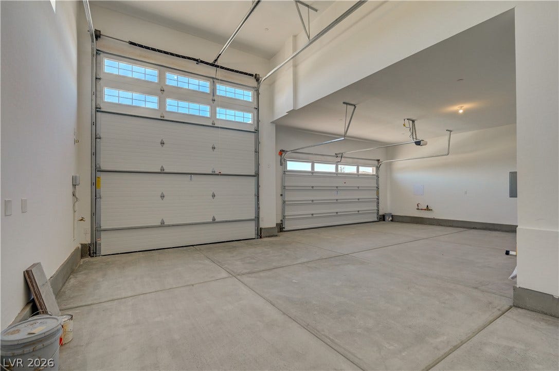 5689 Searching Bear Court, Las Vegas, NV 89149 A spacious and practical garage awaits, featuring two large doors and ample room for vehicles or storage.