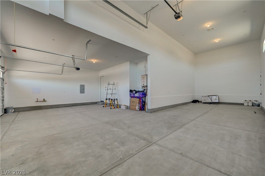 5689 Searching Bear Court, Las Vegas, NV 89149 A spacious, well-lit garage offers ample room and a pristine concrete floor for diverse storage and vehicle needs.