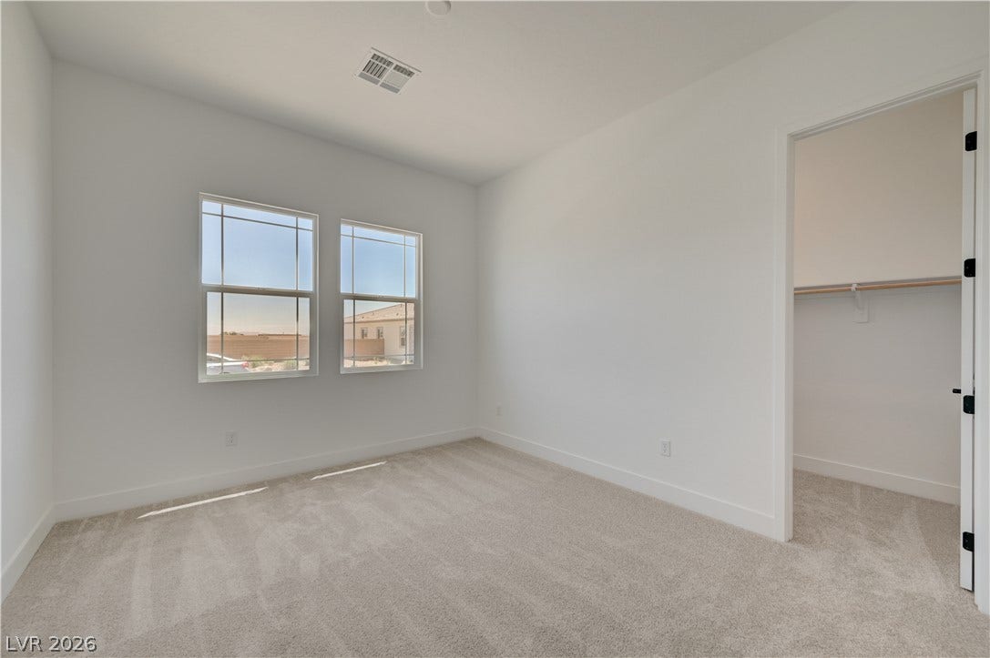 5689 Searching Bear Court, Las Vegas, NV 89149 A well-lit bedroom provides ample natural light and a neutral palette, offering a serene retreat.