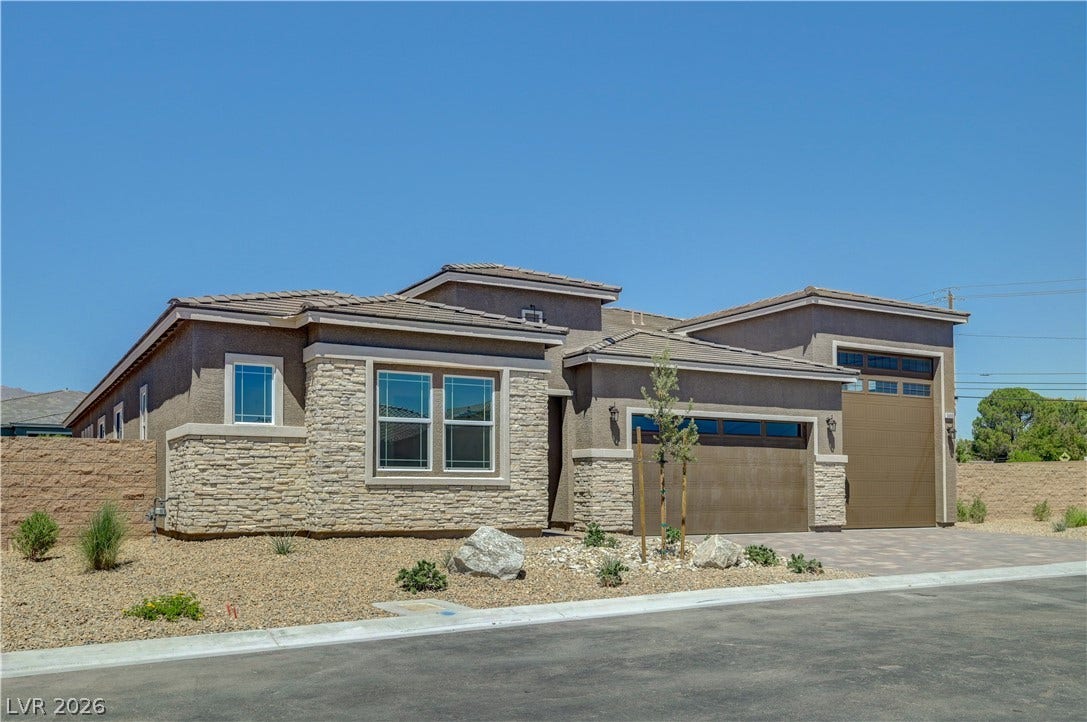 5689 Searching Bear Court, Las Vegas, NV 89149 A desert-modern residence with a stone facade and paver driveway presents exceptional curb appeal.