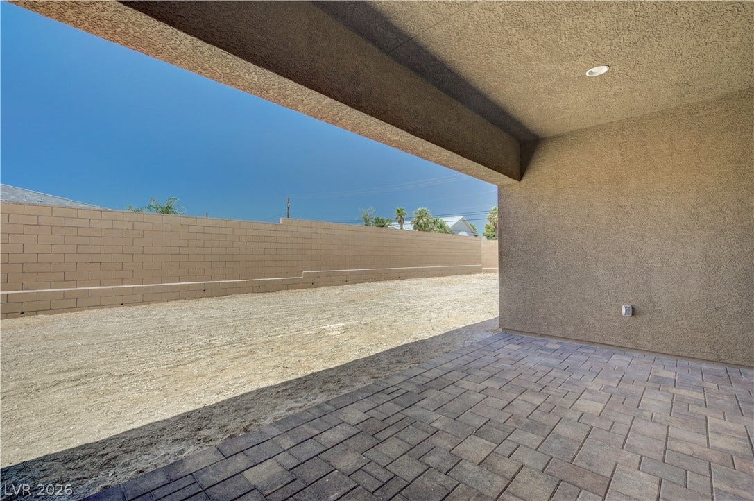 5689 Searching Bear Court, Las Vegas, NV 89149 A covered patio offers an ideal outdoor living space, transitioning to a spacious, ready-to-customize backyard.