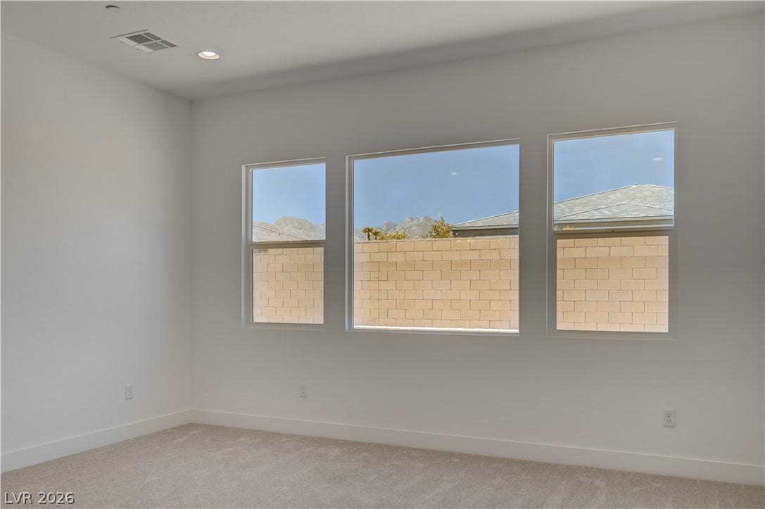 5689 Searching Bear Court, Las Vegas, NV 89149 A quiet bedroom offers serene views and a plush carpet, creating a peaceful retreat.