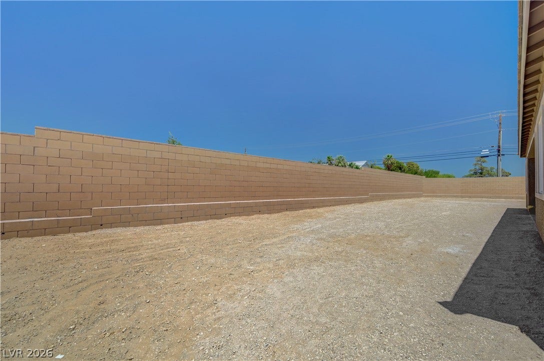 5689 Searching Bear Court, Las Vegas, NV 89149 A spacious, bare yard awaits your landscaping vision, enclosed by a robust block wall for privacy.