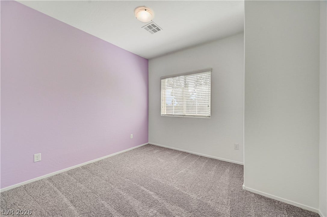 2455 Sunflower Days Avenue, #1056, North Las Vegas, NV 89031 Plush carpeting and natural light highlight this comfortable bedroom space.