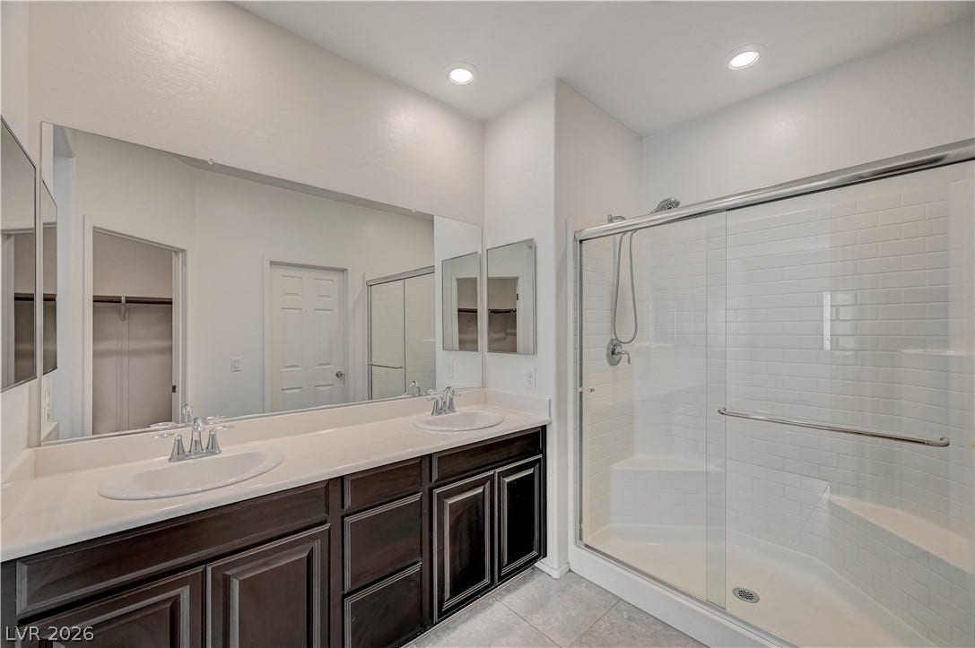 2455 Sunflower Days Avenue, #1056, North Las Vegas, NV 89031 Double vanities and a glass-enclosed walk-in shower highlight this modern bathroom.