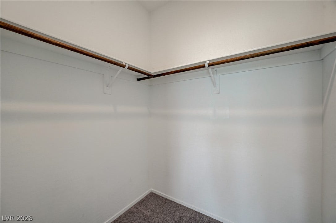 2455 Sunflower Days Avenue, #1056, North Las Vegas, NV 89031 Continuous hanging rods and upper shelving maximize storage space within this walk-in closet.