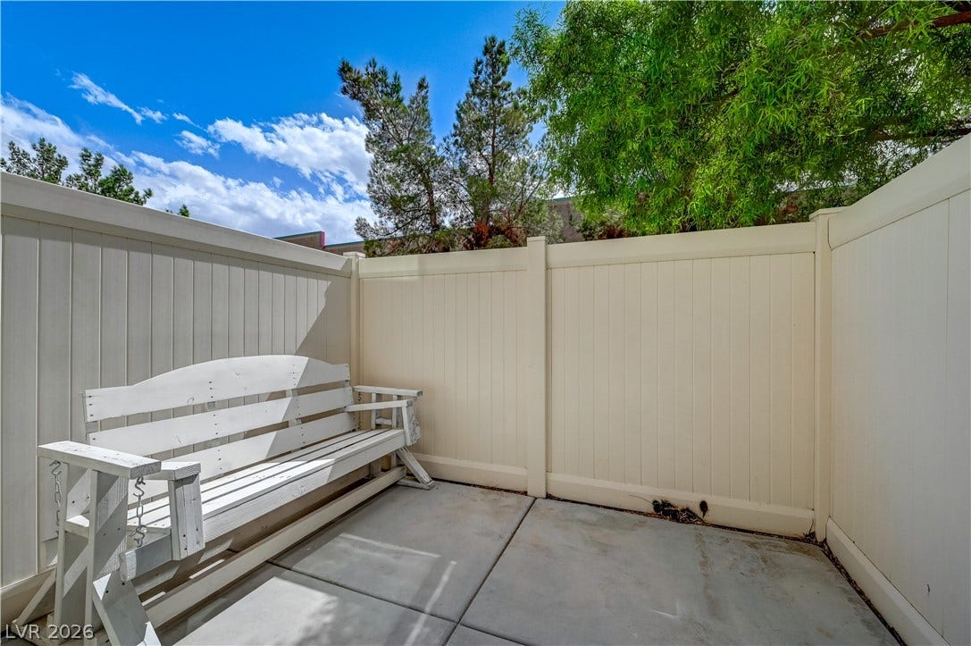 2455 Sunflower Days Avenue, #1056, North Las Vegas, NV 89031 Secure vinyl fencing encloses a private concrete patio under open skies.