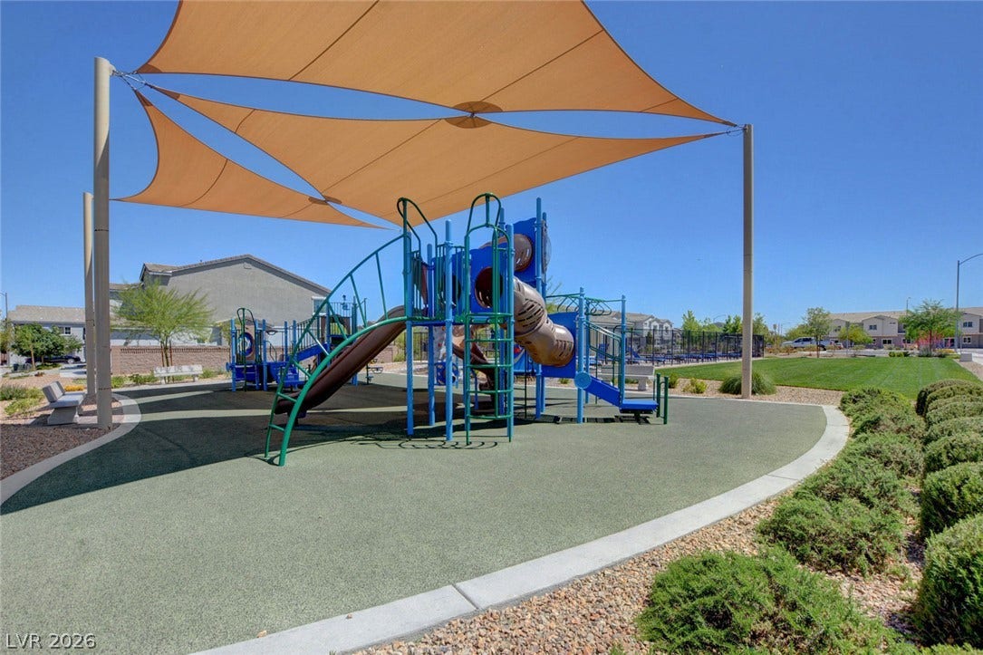 2455 Sunflower Days Avenue, #1056, North Las Vegas, NV 89031 Shade sails cover a modern neighborhood playground with soft safety surfacing and manicured surrounding lawns.