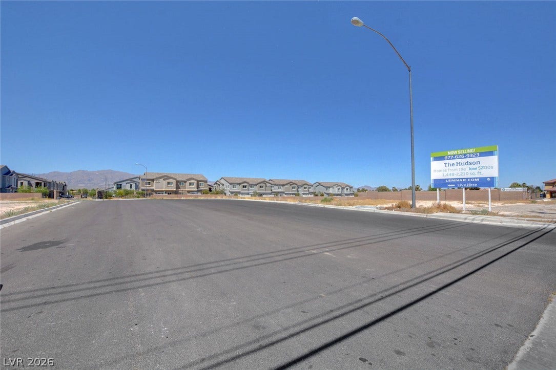 2455 Sunflower Days Avenue, #1056, North Las Vegas, NV 89031 Paved roads wind through a newly developed neighborhood under clear desert skies.