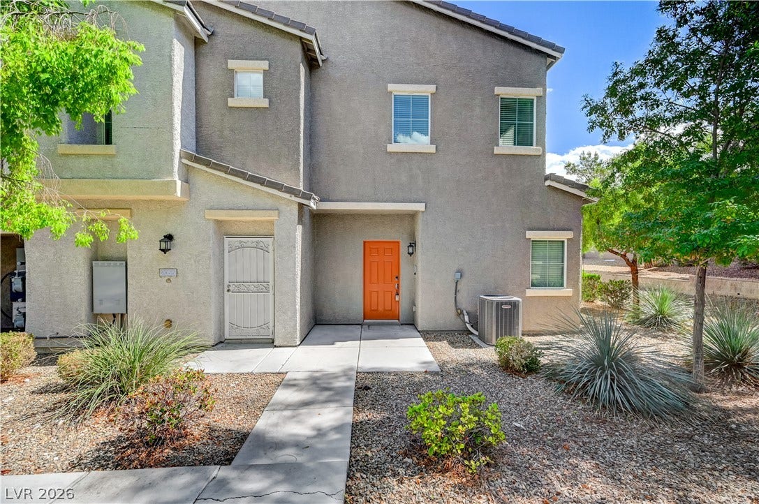 2455 Sunflower Days Avenue, #1056, North Las Vegas, NV 89031 A concrete walkway leads to the private entry of this multi-level stucco home.