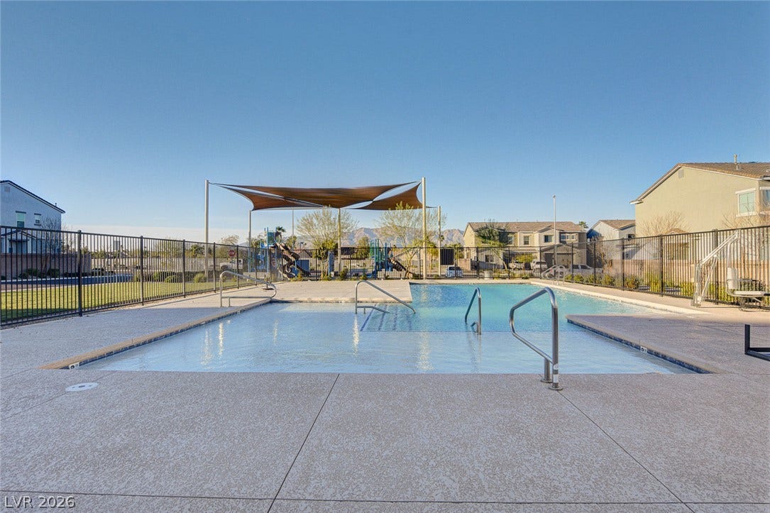 2455 Sunflower Days Avenue, #1056, North Las Vegas, NV 89031 An inviting community swimming pool features a secure fenced surround and adjacent shaded playground.