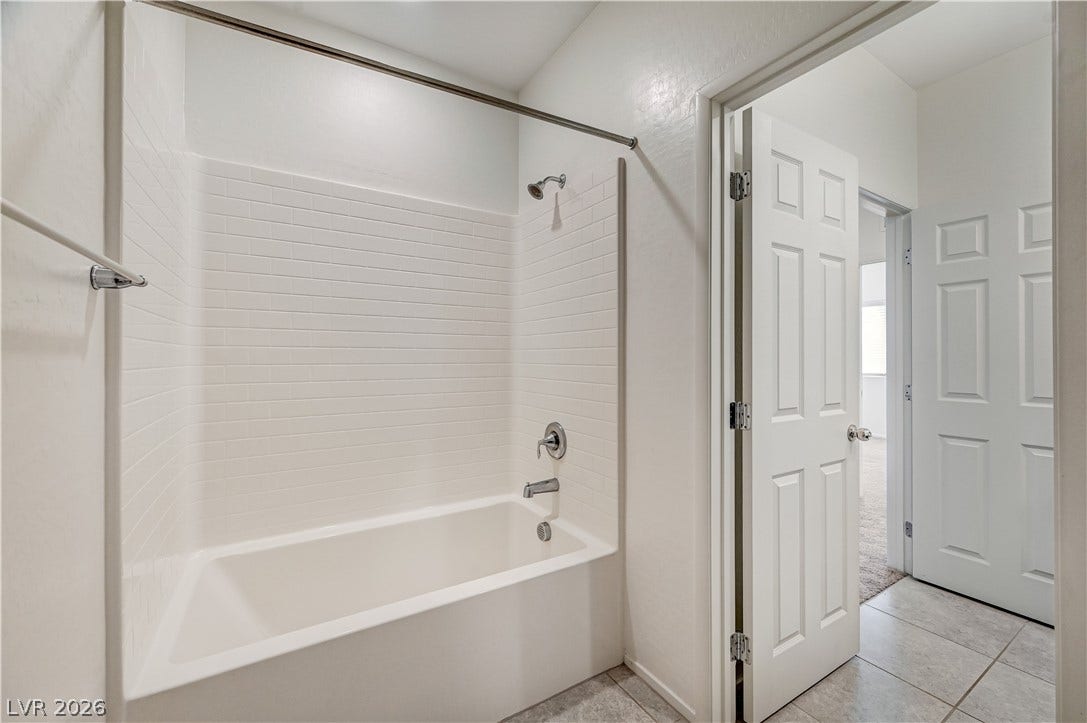 2455 Sunflower Days Avenue, #1056, North Las Vegas, NV 89031 Tiled tub surround and clean architectural lines define this functional bathroom space.