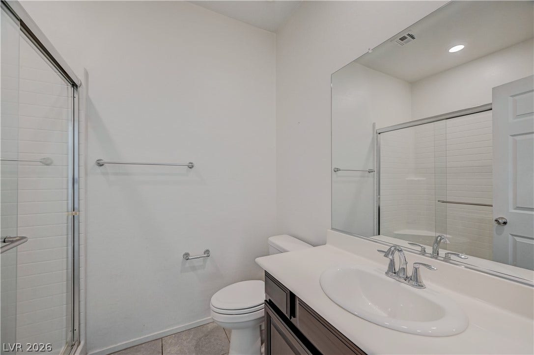 2455 Sunflower Days Avenue, #1056, North Las Vegas, NV 89031 Clean lines and a spacious vanity define this modern, neutral bathroom.