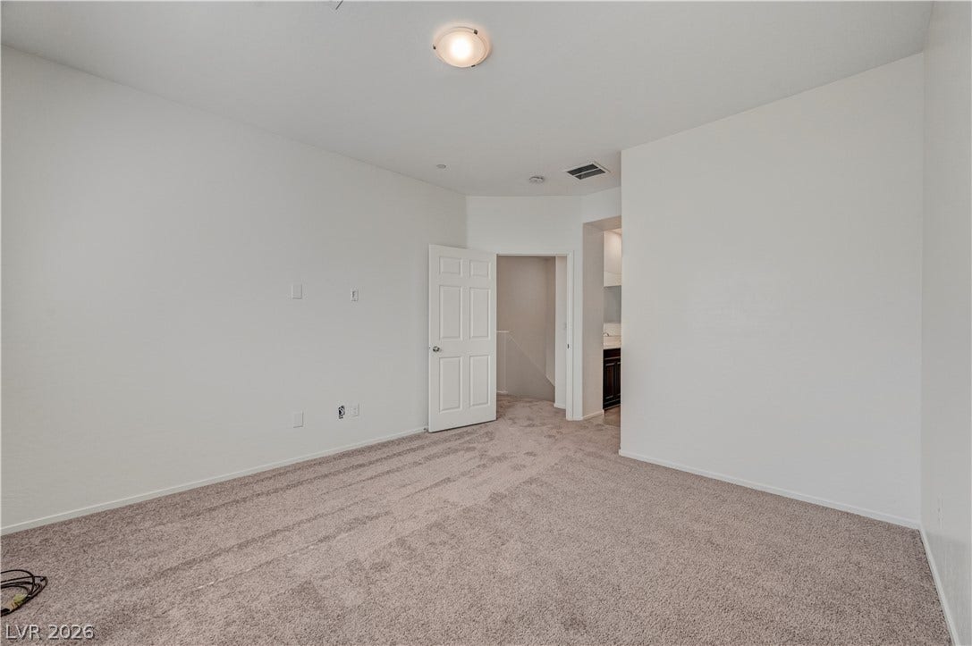 2455 Sunflower Days Avenue, #1056, North Las Vegas, NV 89031 An open bedroom layout features wall-to-wall carpeting and clean white walls.