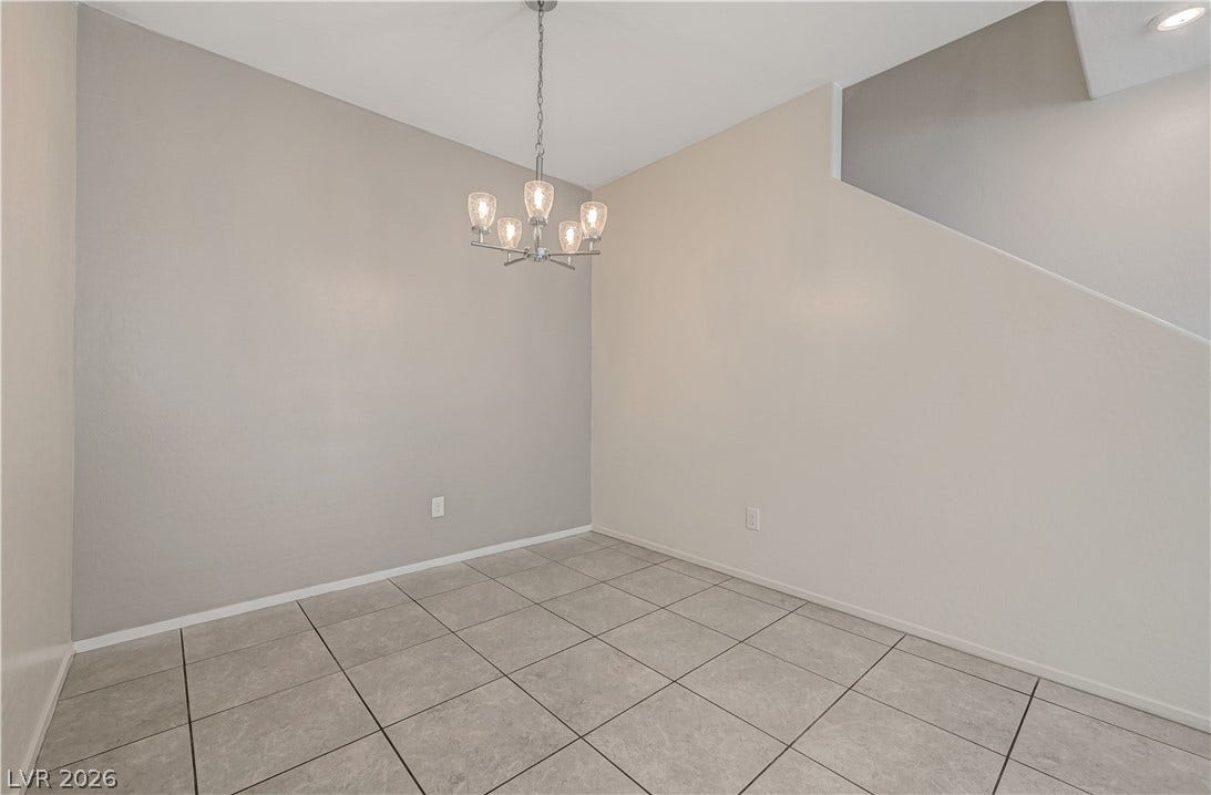 2455 Sunflower Days Avenue, #1056, North Las Vegas, NV 89031 Tiled flooring and a modern light fixture define this versatile dining area near the stairs.