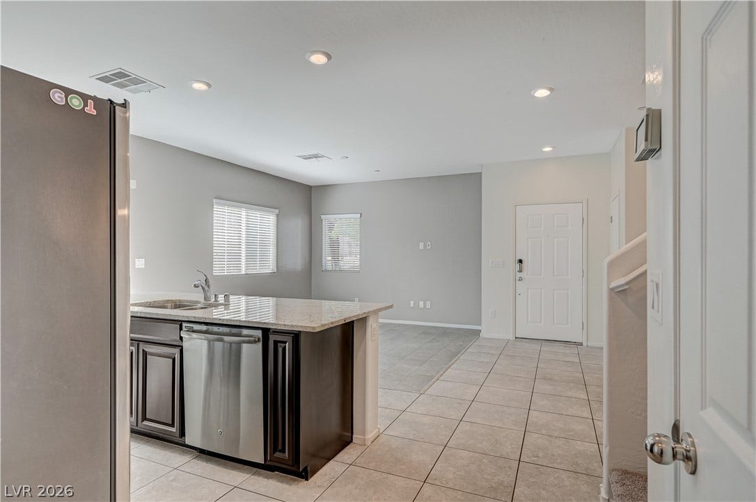 2455 Sunflower Days Avenue, #1056, North Las Vegas, NV 89031 Polished tile flooring and granite counters define this open transition from entry to kitchen.