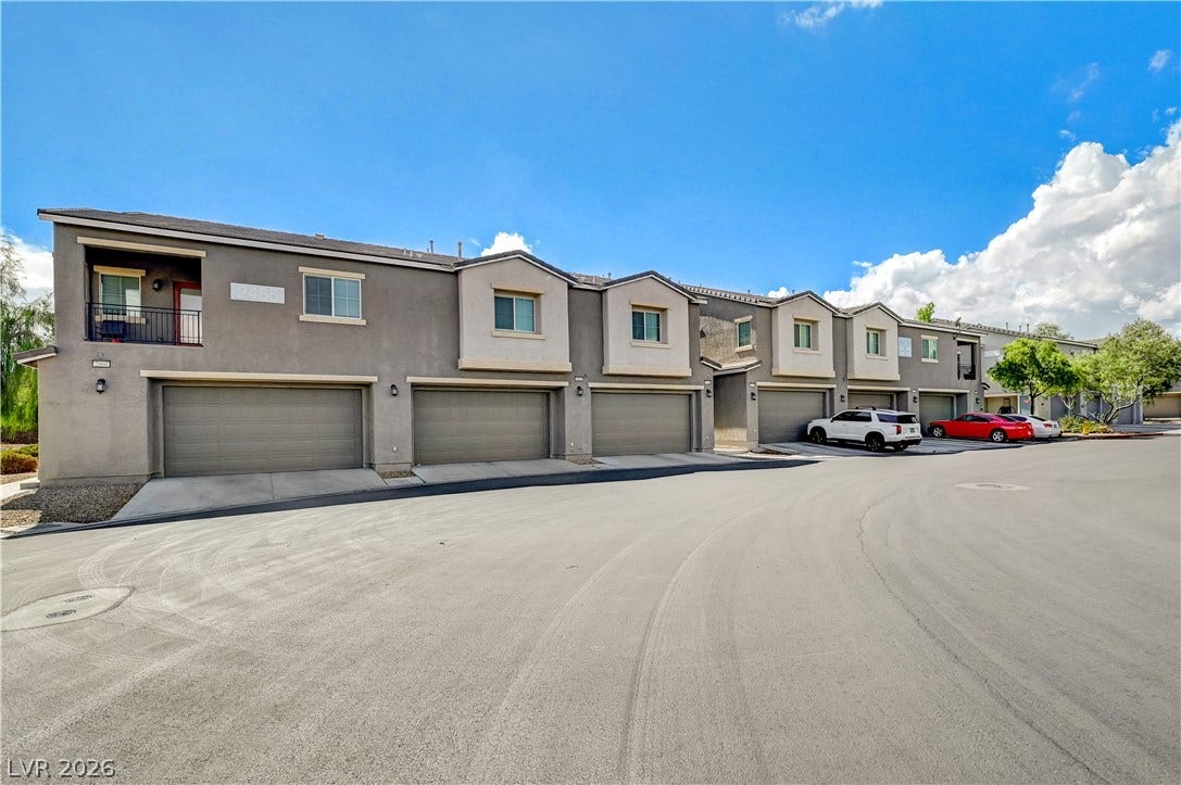 2455 Sunflower Days Avenue, #1056, North Las Vegas, NV 89031 Multi-vehicle garages line the paved driveway of this modern two-story townhome complex.