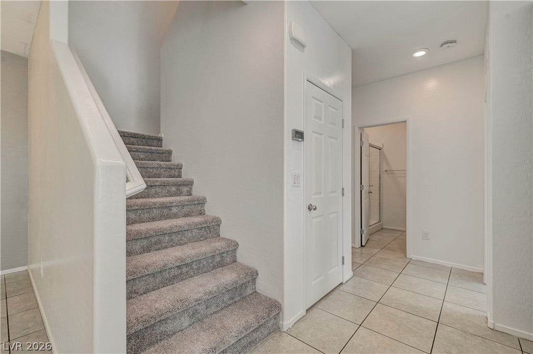 2455 Sunflower Days Avenue, #1056, North Las Vegas, NV 89031 A tiled hallway connects the main living spaces next to a carpeted staircase.