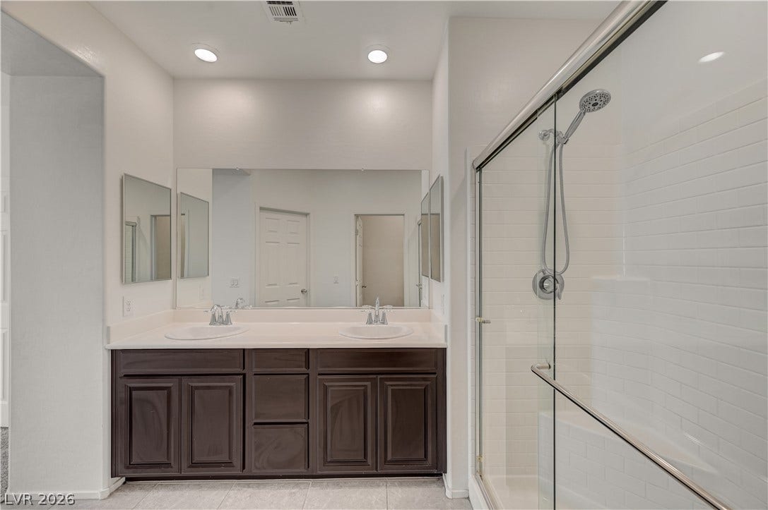 2455 Sunflower Days Avenue, #1056, North Las Vegas, NV 89031 Clean lines and a spacious dual vanity define this modern bathroom with a glass shower.