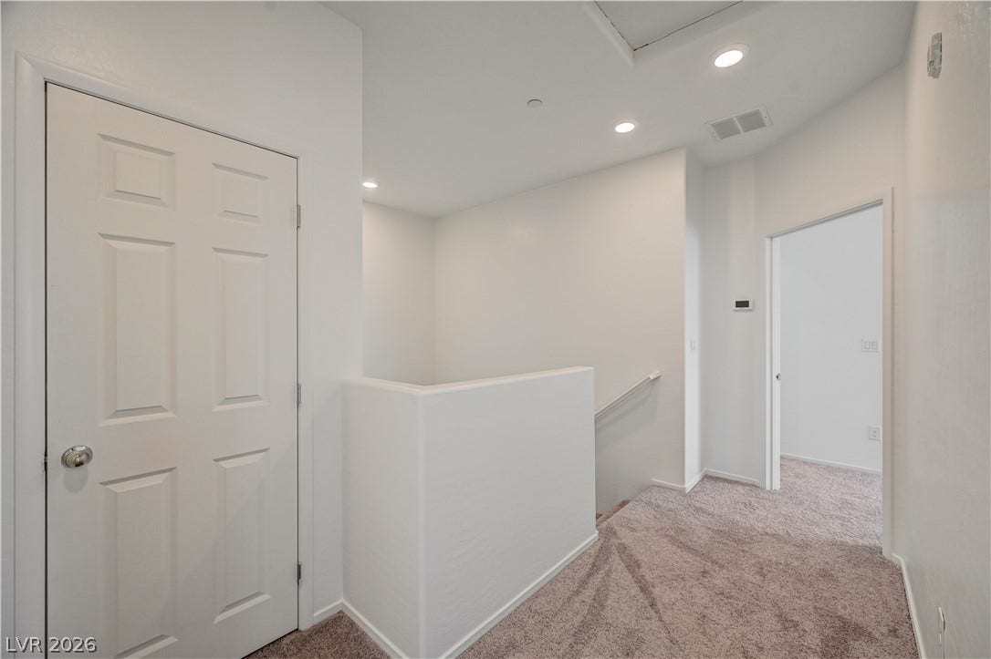 2455 Sunflower Days Avenue, #1056, North Las Vegas, NV 89031 Recessed lighting illuminates this upper landing with plush carpeting and crisp white walls.